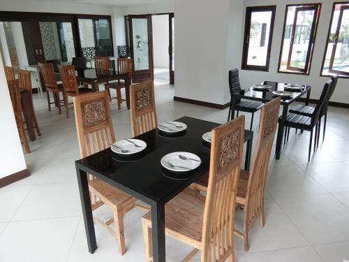 a dining room with a black table and chairs at Baan Sang Singh in Chiang Mai