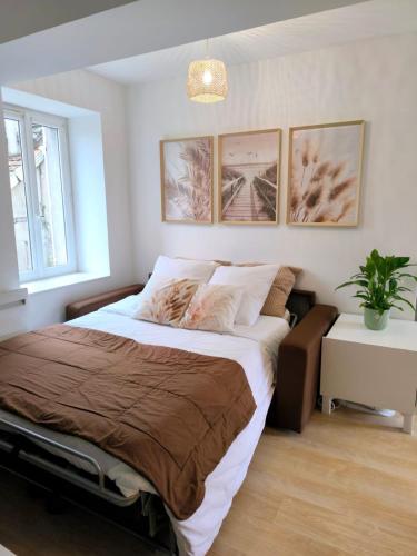 a bedroom with a bed and a potted plant at Gîte Ocrinien Étape vélo face à Gien in Saint-Martin-sur-Ocre