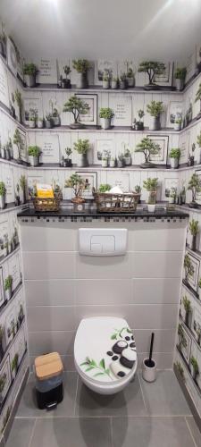a bathroom with a toilet with potted plants on the wall at Studio Lindois in Lalinde