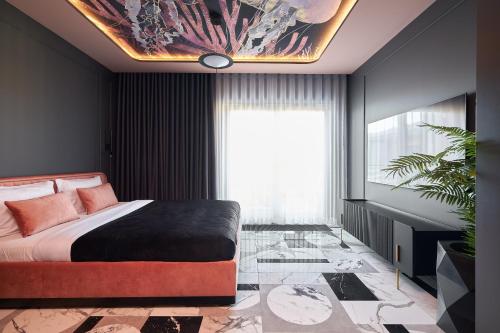 a bedroom with a bed with a painting on the wall at INA Rent - Apartamenty Czysta Delux in Wrocław