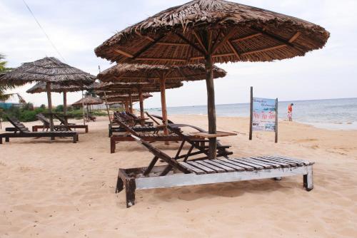 a group of chairs and umbrellas on a beach at Thai Tan Tien Hotel in Phu Quoc