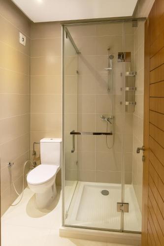 a bathroom with a toilet and a glass shower at 3BR Near Airport Secure,Equipped stay and transit in Nouaseur