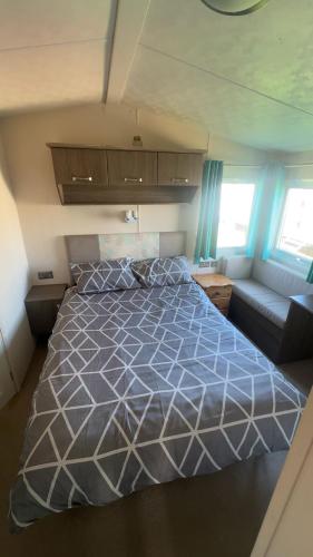 a bedroom with a bed and a couch at 16 orchid meadows in Ashington