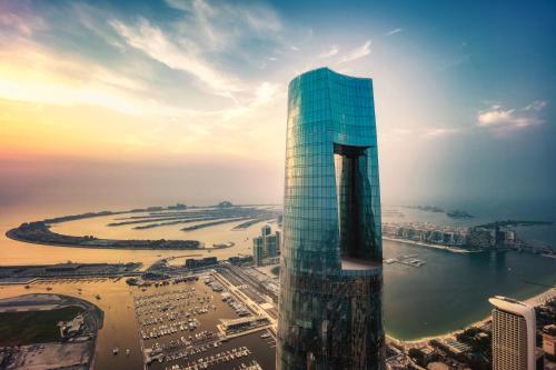 a tall glass building next to a body of water at Ciel Dubai Marina, Vignette Collection by IHG in Dubai