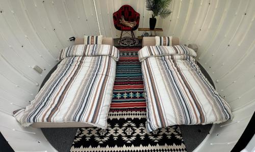 two beds in a small room with a chair at Kuruma Asobi Adventure Field Appi - Camp - Vacation STAY 42095v in Hachimantai