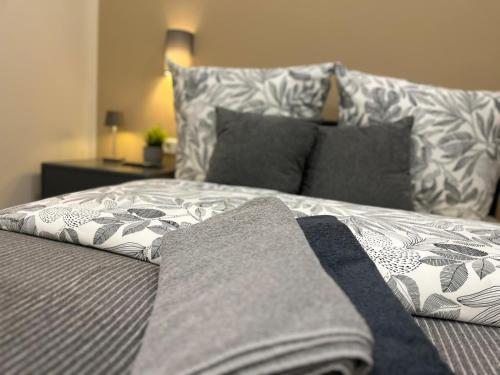 a bed with gray and white sheets and pillows at Live-In Room 5 - Klimatisiert - Coffee for free - in Karlsruhe