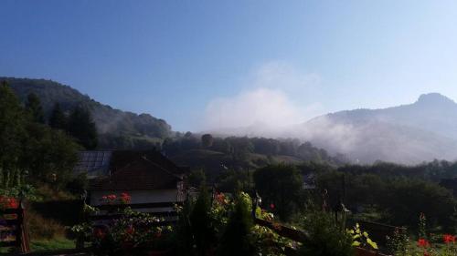 a view of a mountain with clouds in the distance at Pensiunea Casa Motilor in Bucium