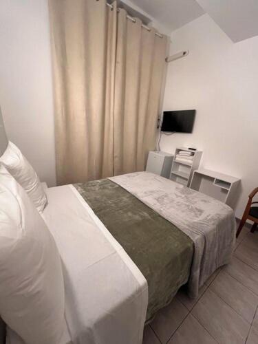 a bedroom with a bed and a desk and a television at Hotel Relax in Marseille
