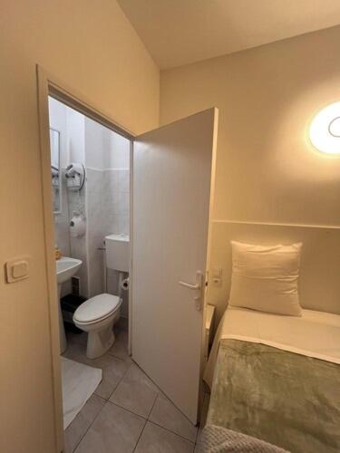 a bathroom with a bed and a toilet and a sink at Hotel Relax in Marseille