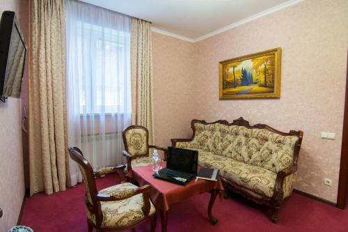 a living room with a couch and a table with a laptop at Grand Christer Hotel in Kyiv