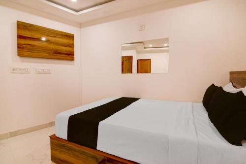 a bedroom with a white bed and a mirror at SPOT ON Night Owl Hotel &guest House in Bārāsat