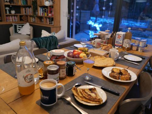Una mesa cubierta con platos de comida y bebidas. en La Dame du Lac à Sevrier, en Sévrier