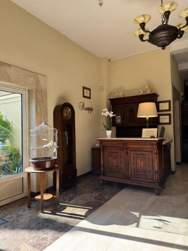 a room with a desk and a clock and a window at Hotel Mateo in Stopnica
