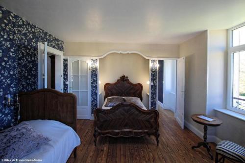 ein Schlafzimmer mit einem Bett und einem Stuhl darin in der Unterkunft Suite familiale, Au Fil du Temps in Fougerolles