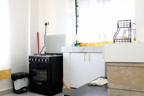 een keuken met een zwart fornuis en een wit aanrecht bij Willary Heights Apartment in Bungoma