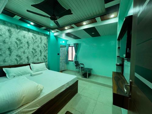 a bedroom with a large bed with blue lighting at Hotel O Silk Premium in Khagaul