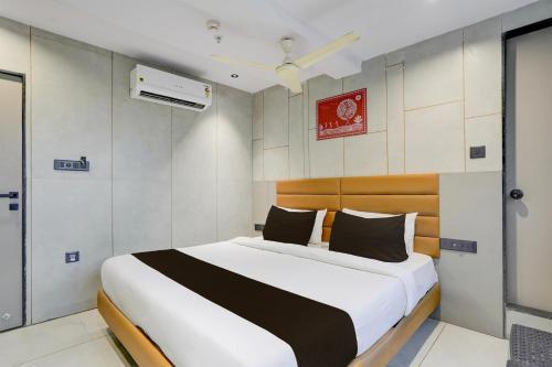 una camera da letto con un letto grande in una stanza di Hotel O by OYO Olive7 a Surat