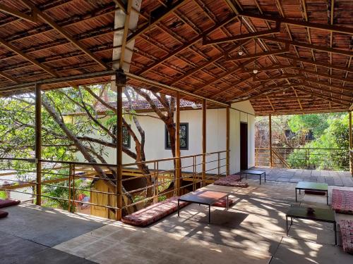 a large pavilion with a tree in the middle at Halfway Home Hilltop in Gokarna