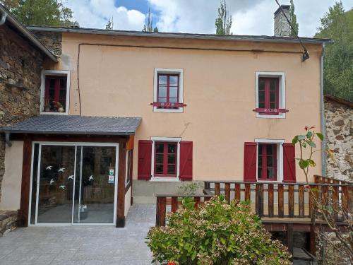 an external view of a house with red shutters at Ecogite du Mas de Trape in Talau