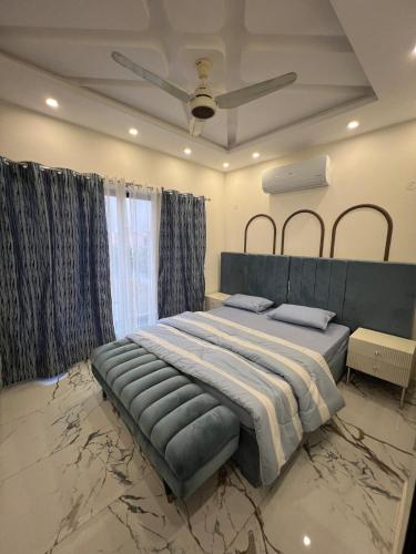 a bedroom with a large bed and a ceiling fan at Brand New Vacation House in Lahore