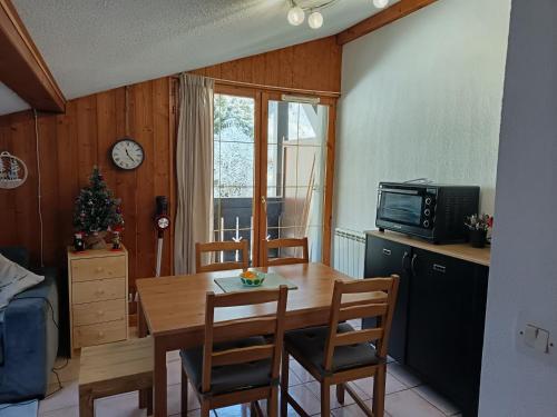 Les Contamines Montjoie في Le Cugnon: مطبخ مع طاولة وكراسي وتلفزيون