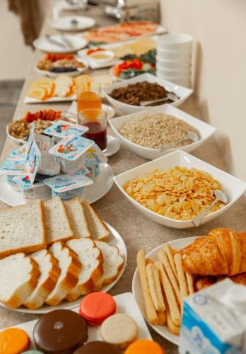 een tafel met veel verschillende soorten voedsel bij Merci in Tashkent Hotel in Tasjkent