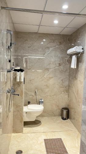 a bathroom with a shower and a toilet and a sink at The Eco Satva Kota - Vegetarian with all Options in Kota