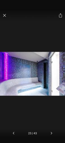 a bathroom with a tub with purple lights on the wall at Hevenia Klifowa 5 B Apartament 33 in Rewal