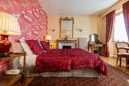 Un dormitorio con una cama roja y un espejo. en Hôtel Restaurant Million, en Albertville