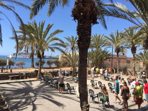 a group of people walking around a park with palm trees at Cindy Golden Bay SeaView Terrace in El Guincho