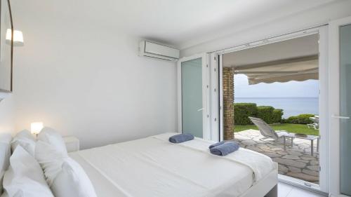 a white bedroom with a view of the ocean at Villa Sand and Sea in Pelekas