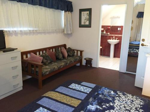 uma sala de estar com um sofá e um lavatório em Aarn House B&B Airport Accommodation em Perth
