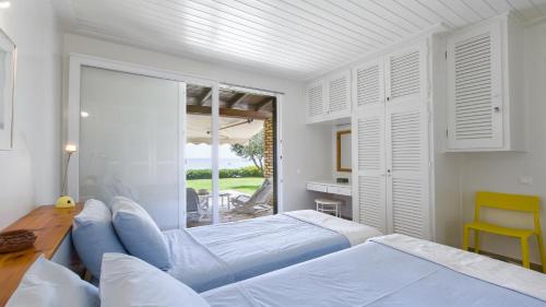 una camera da letto con due letti, un tavolo e una finestra di Villa Marina a Pelekas