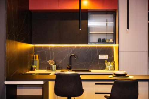 a kitchen with a sink and two chairs at Kron in Novi Sad