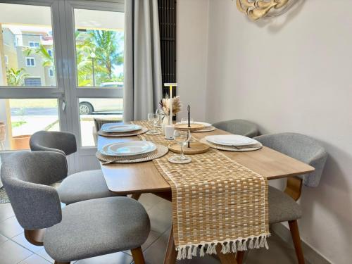 Un comedor con mesa y sillas de madera. en Zephyr House 3BR Pool, Rooftop & Ocean View, en Grand Gaube