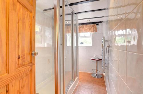 Waterswallow Cottage في Hutton le Hole: حمام مع دش وباب زجاجي