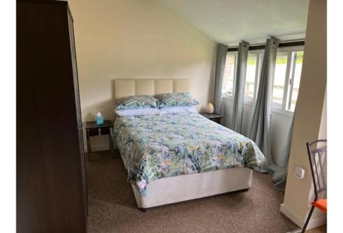 una camera da letto con letto, copriletto e cuscini di Halfway Inn a Morden