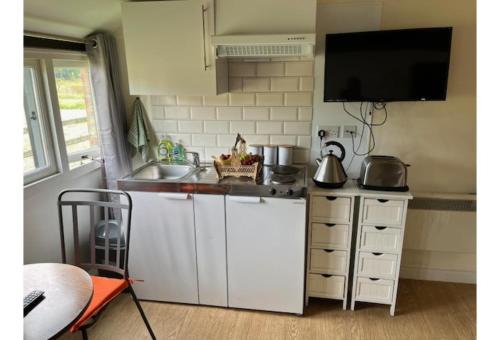 eine kleine Küche mit einer Spüle und einer Theke in der Unterkunft Halfway Inn in Morden