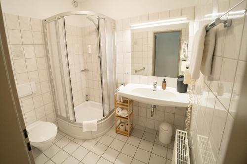 a bathroom with a shower toilet and a sink at The Resting Place in Lemgo