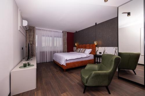 a hotel room with a bed and a chair at Kron in Novi Sad