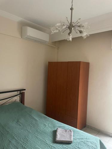 a bedroom with a green bed and a brown cabinet at Serres Heart Suite in Serres