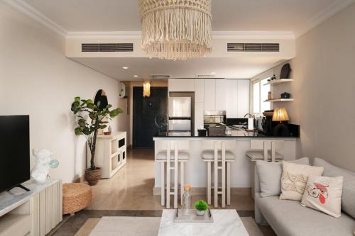 a living room with a couch and a kitchen at New Giza Boho Bliss in Abū Rawwāsh