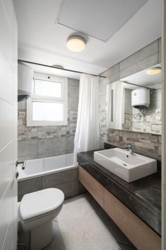 a white bathroom with a sink and a toilet at New Giza Boho Bliss in Abū Rawwāsh
