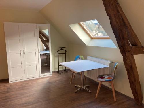 a table and chairs in a room with a skylight at B&B L'Atout de France in Fléré-la-Rivière