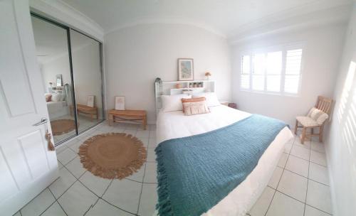 a bedroom with a large bed with a blue blanket at Palmview Escape in Yorkeys Knob