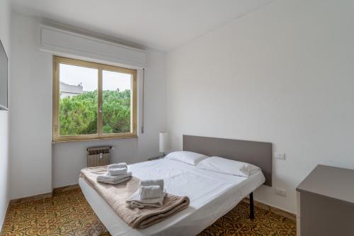 a white bedroom with a bed with towels on it at Andora See Breeze in Marina dʼAndora