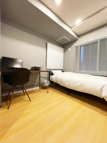 a room with two beds and a desk and a computer at カレラ豊平2nd in Sapporo