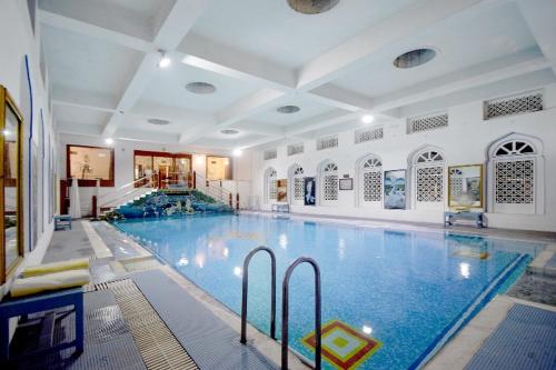 The Hari Mahal-A Luxury Heritage Suit Jaipur City Centre في جايبور: حمام سباحة كبير في مبنى كبير