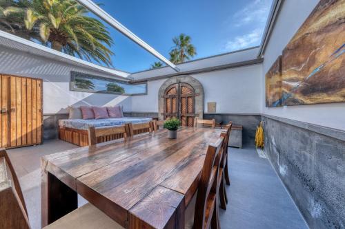 a dining room with a table and a bed at Casita Malvika - Luxury and Sea view - 1min to the Beach By Lanzarote Vacation Homes in Costa Teguise