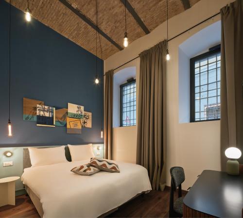 ein Hotelzimmer mit Bett und Schreibtisch in der Unterkunft URBANAUTS STUDIOS Minelli in Triest